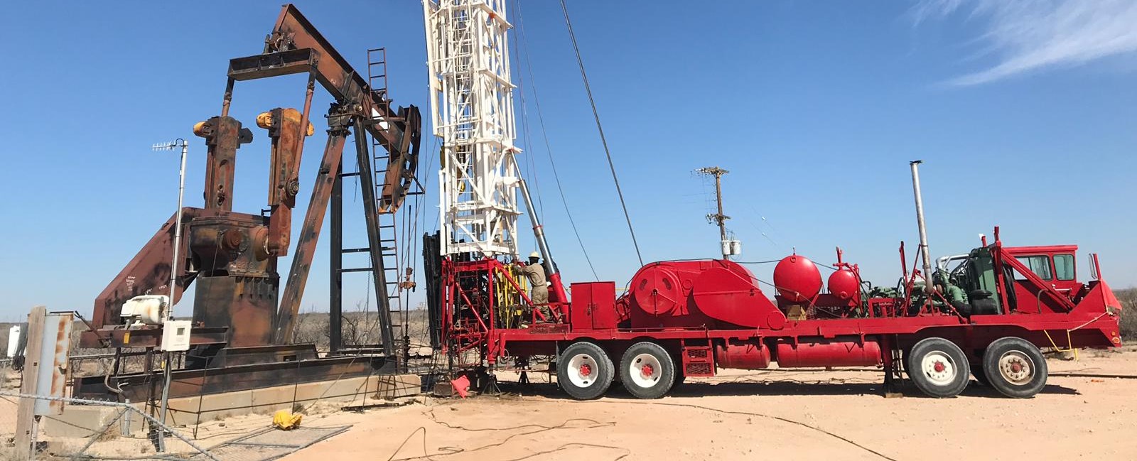 Workover rig and producing pumping unit during Sunergon field operations